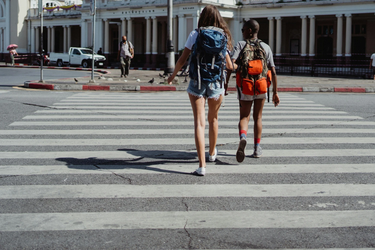 Chrissi und Daniel – 2 Frauen gehen über einen Zebrastreifen